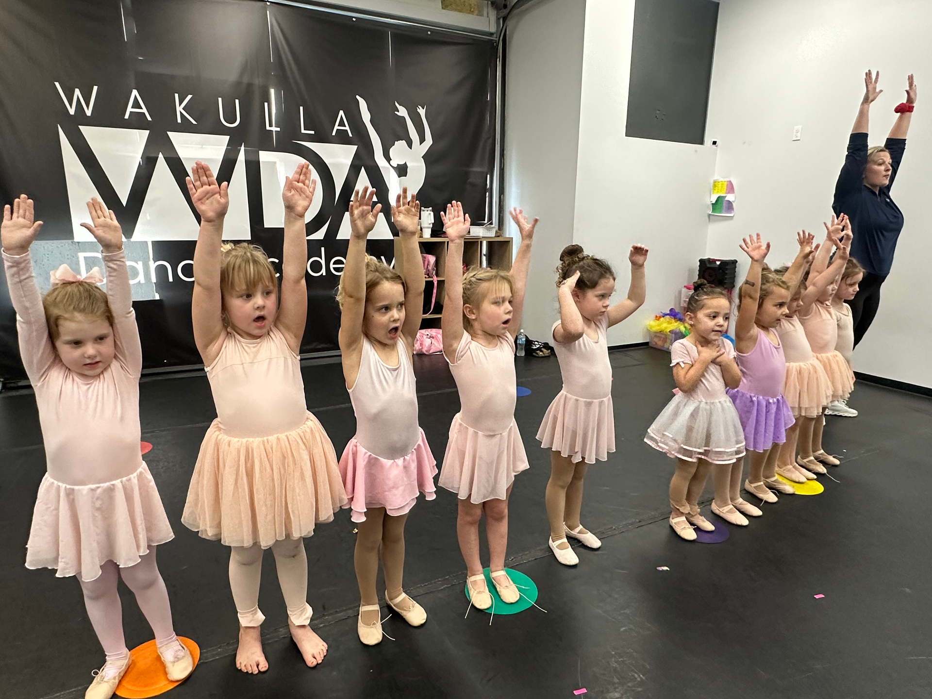Wakulla tiny dancers in a line with arms raised