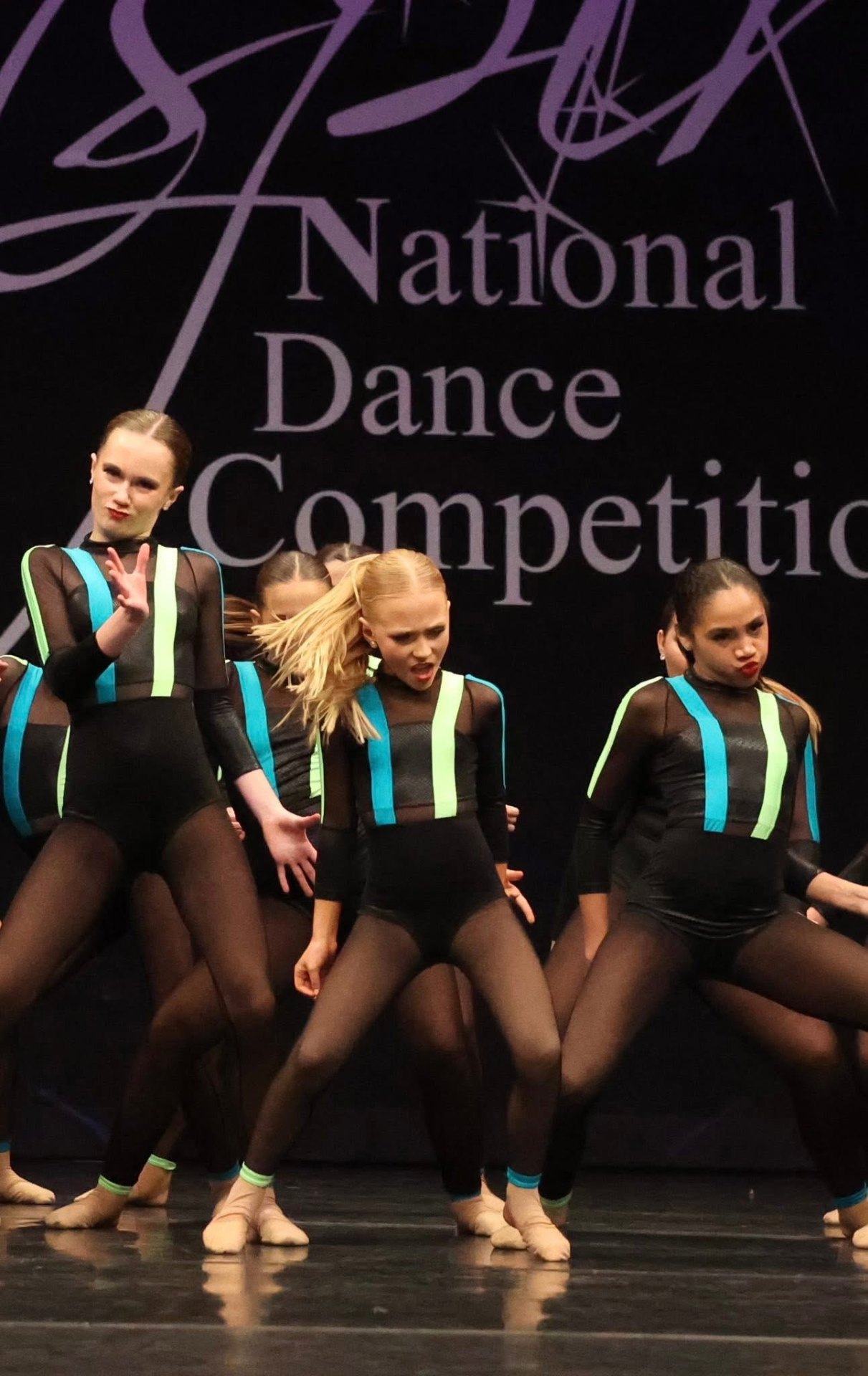 Team performing in black and neon at Nationals