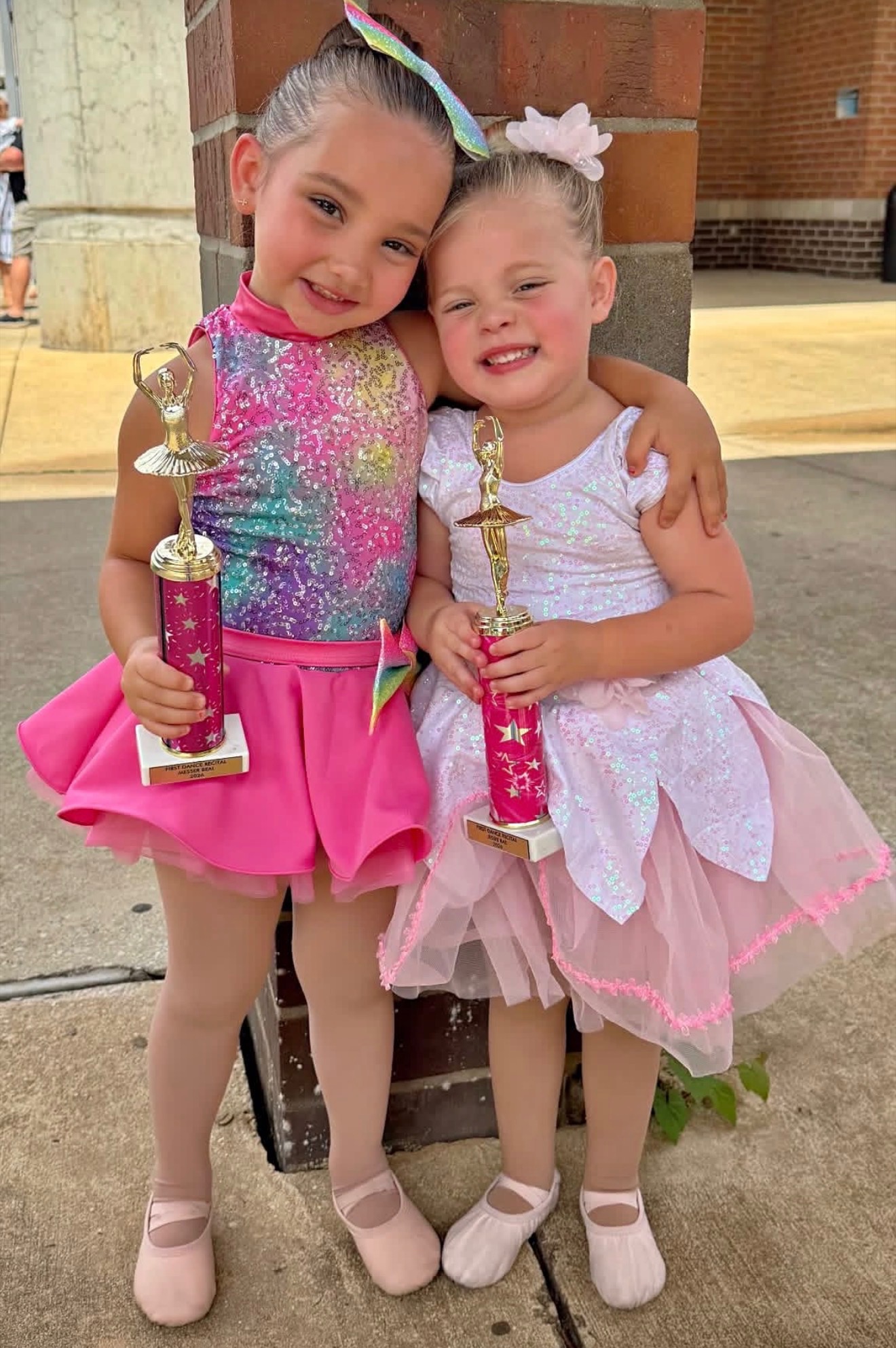 Two young dancers holding trophies